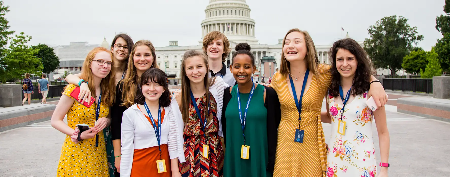 A group of 9 students posing for a photo in front of the US Capitol.