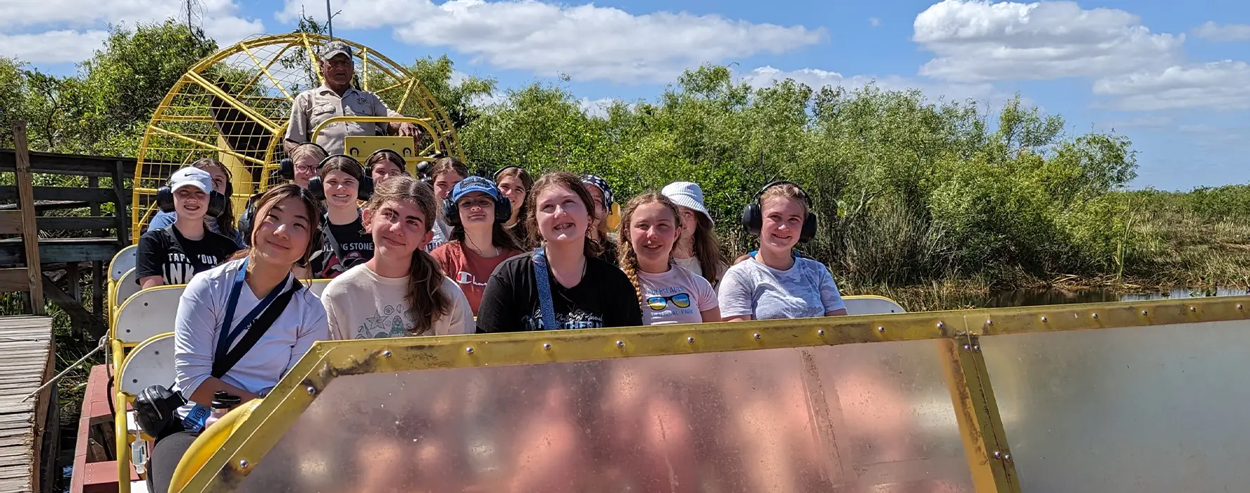 A group of students posing for a photo on a fanboat in Florida.
