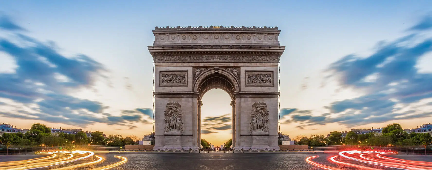 A photo of the sun setting with the Arc de Triomphe in the foreground.